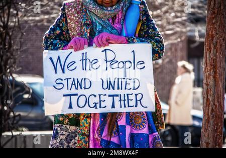 Donna anziana in colorato patchwork boho detiene segno di protesta lettura noi la gente stare Uniti insieme - sfondo sfocato Foto Stock