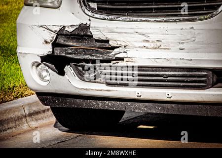 Il SUV anteriore bianco è stato distrutto con il guscio esterno del veicolo strappato per rivelare ciò che è sotto-parcheggiato da marciapiede e erba - Closeup Foto Stock