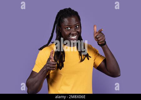 Carismatico bel giovane uomo nero che punta alla fotocamera Foto Stock