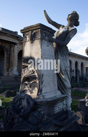 Il monumento all’attore Augustus ‘Gus’ Harris, salutato da una donna elegantemente dermopata, il Great Circle Brompton Cemetery West London UK Foto Stock