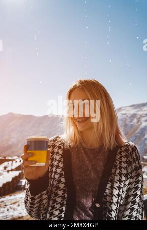 Ucraino femmina bere caffè caldo da tazza usa e getta in natura, montagne Foto Stock