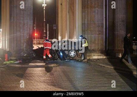 Berlino, Germania. 16th Jan, 2023. Un'auto distrutta si trova tra due pilastri della porta di Brandeburgo. Un'auto si è schiantata in un pilastro della porta di Brandeburgo a Berlino. In macchina, vigili del fuoco trovato un uomo morto, ha detto un portavoce della polizia presto Lunedi mattina. Credit: Annette Riedl/dpa/Alamy Live News Foto Stock