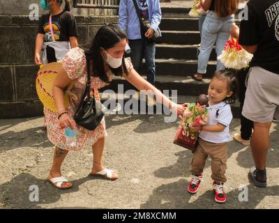 Manila, Filippine. 15th Jan, 2023. Un bambino cerca di tenere una replica Santo Niño come sua madre la assiste. I devoti cattolici si affollano nella parrocchia di Santo Niño de Tendo, conosciuta anche come Chiesa di Tendo a Manila, con il loro Sto. Niño repliche a casa per la sua benedizione. L'icona cattolica più antica del paese, il Santo Niño o il titolo cattolico romano del bambino Gesù. Associata ad un'immagine religiosa del Cristo bambino, ampiamente venerata come miracolosa dai cattolici filippini. Credit: SOPA Images Limited/Alamy Live News Foto Stock