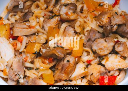 spaghetti istantanei o wok con verdure e carne di pollo con spezie e salsa calda. Primo piano con piatti tradizionali asiatici Foto Stock