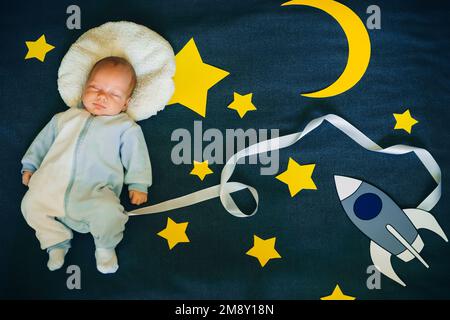 bambino piccolo che dorme in un vestito dell'astronauta sullo sfondo del cielo stellato con stelle e una nave spaziale. Vista dall'alto, giacitura piatta Foto Stock