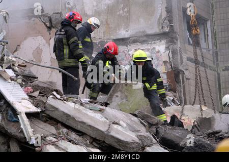 Non esclusiva: DNIPRO, UCRAINA - 15 GENNAIO 2023 - i soccorritori rimuovono le macerie e cercano persone in un blocco di appartamenti colpito da un razzo lanciato da Foto Stock