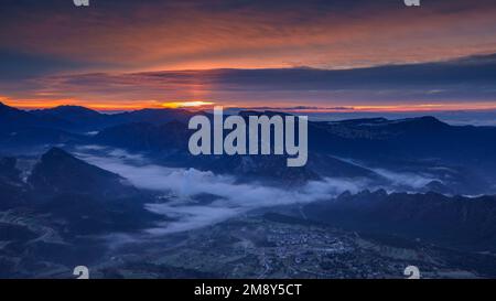 Alba nella valle di Vall de Lord con nebbia sul serbatoio e nuvole rossastre. Visto da Port del Comte (Solsonès, Lleida, Catalogna, Spagna) Foto Stock