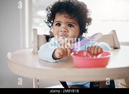 No, non mi piace questo. una ragazza adorabile seduta da sola in cucina e che mangia la sua colazione. Foto Stock