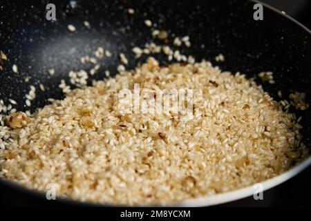 Processo di cottura del risotto. Riso Arborio in padella in cucina casalinga. Piatto di cucina italiana Foto Stock