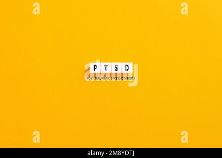 Blocchi di lettere bianche su sfondo giallo con l'acronimo PTSD post traumatico stress disorder. Foto Stock