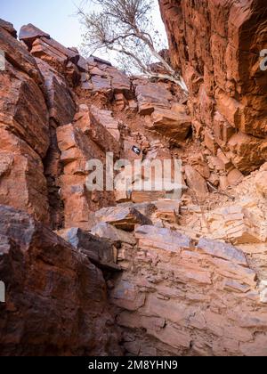 Le frecce fanno il percorso fino alla scanalatura, il monte Bruce (Punurrunha), il parco nazionale di Karijini, l'Australia occidentale Foto Stock