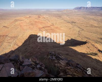 L'altopiano della cima getta un'ombra sulla pista sulla cresta occidentale, il Monte Bruce (Punurrunha), il Parco Nazionale Karijini, l'Australia Occidentale Foto Stock