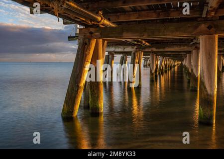 Molo di Sopot sul Mar Baltico all'alba nella località turistica di Sopot in Polonia, vista sotto lo storico molo in legno. Foto Stock