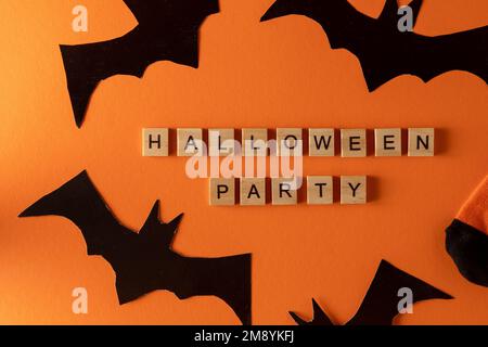 Calzini arancioni con pipistrelli. Costume di abbigliamento per la festa di Halloween. Vista dall'alto della calza vivace e multicolore. Frase in lettere di legno. Parola. Foto Stock