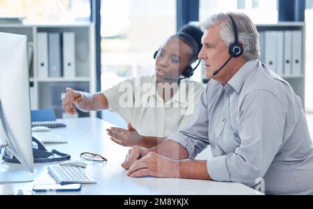 ILL vi mostra un modo più veloce per farlo. Due agenti di call center che lavorano insieme su un computer in ufficio. Foto Stock
