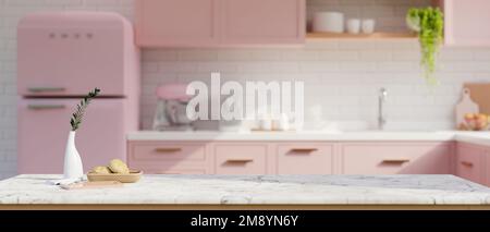 Spazio copia per l'esposizione dei prodotti su un tavolo in marmo bianco con decorazioni in una splendida cucina rosa pastello con armadio da cucina rosa, frigorifero rosa e angolo cottura Foto Stock