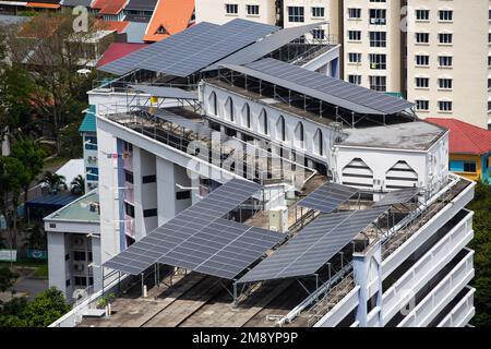 Pannelli solari installati sul tetto di case pubbliche per raccogliere energia dal clima tropicale a Singapore. Foto Stock