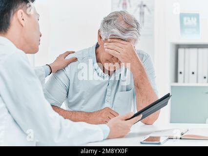 Im mi dispiace essere il portatore di cattive notizie. un uomo maturo seduto e confortato dal medico durante una consultazione in clinica. Foto Stock