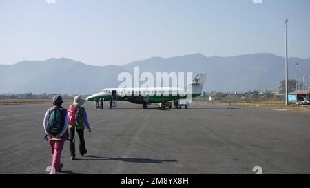 POKHARA, NEPAL - 28 GENNAIO: I turisti camminano verso un piccolo aereo interno, Yeti Airlines a Pokhara il 28 gennaio 2010.Un aereo simile interno si è schiantato a breve Foto Stock