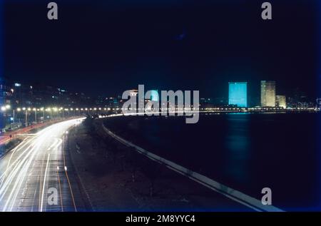 Marine Drive è una passeggiata di 3 chilometri lungo la Netaji Subhash Chandra Bose Road a Mumbai, India. La strada e il lungomare sono stati costruiti da Pallonji Mistry. Si tratta di una strada in cemento a sei corsie a forma di 'C' lungo la costa di una baia naturale. Confinante con il Mar Arabico, questa famosa strada è un luogo popolare per osservare i tramonti ed è splendida quando è illuminata di notte. Marine Drive, una passeggiata sul lungomare, è una delle principali attrazioni turistiche e ricreative di Mumbai. Foto Stock