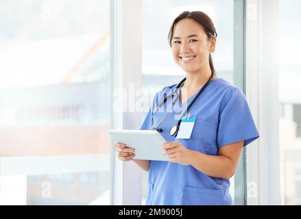 Sono giovani ma hanno esperienza. una giovane infermiera che usa un tablet in ufficio. Foto Stock