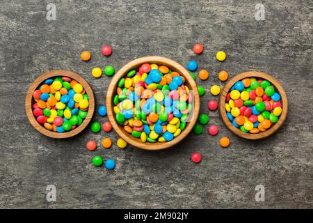 caramelle tonde di colore diverso in ciotola e vasetti. Vista dall'alto di una grande varietà di dolci e caramelle con spazio copia. Foto Stock