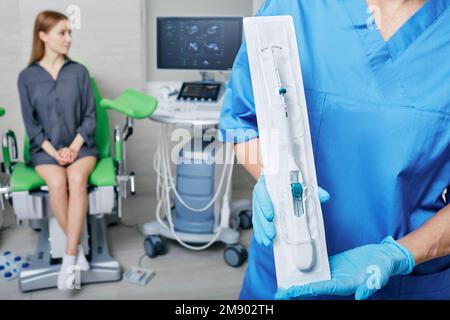 Il medico ginecologo offre alla paziente di utilizzare IUD per prevenire la gravidanza. Dispositivo contraccettivo intrauterino o bobina Foto Stock