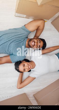 Lo yin al mio yang. Scatto ad angolo alto di una giovane coppia sdraiata sul pavimento nella loro nuova casa. Foto Stock