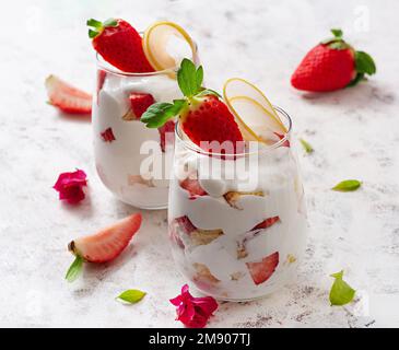 Dolce in bicchiere con biscotto, frutti di bosco e panna montata. Foto Stock