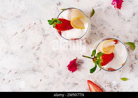 Dolce in bicchiere con biscotto, frutti di bosco e panna montata. Vista dall'alto Foto Stock