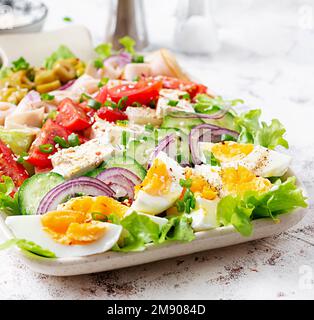 Insalata sana di cobb con prosciutto, cetriolo, pomodoro, olive, formaggio feta e uova. Pranzo chetogenico. Foto Stock