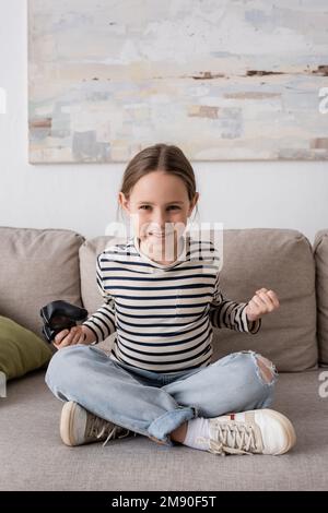 KYIV, UCRAINA - 28 NOVEMBRE 2022: Bambino allegro tenere joystick mentre si gioca il videogioco Foto Stock