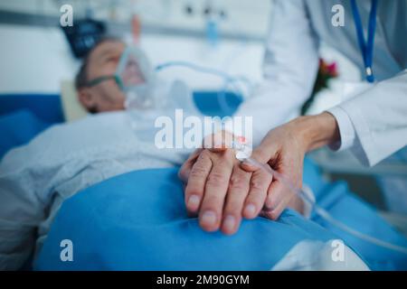 Primo piano dell'infermiere che applica la cannula alla mano del paziente. Foto Stock