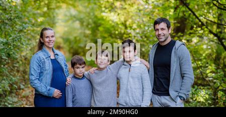 Ritratto di famiglia felice con i bambini in una foresta. Foto Stock