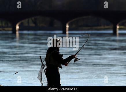 Un pescatore lancia dopo una cerimonia di apertura il giorno di apertura della stagione di pesca del salmone sul fiume Tay al ponte di Kincalven vicino a Meikleour, Perthshire. Data immagine: Lunedì 16 gennaio 2023. Foto Stock