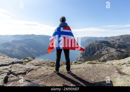 Donna con una sventola bandiera della Norvegia sullo sfondo della natura Foto Stock