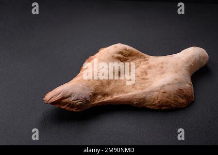 Delizioso pane georgiano fresco croccante lavash cotto al forno su uno sfondo di cemento scuro Foto Stock