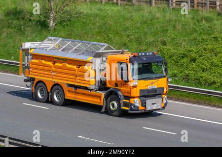 Autostrade Inghilterra Orange VOLVO FE320 6X4 GIORNO 7698cc ROMAQUIP autocarro gritting, una nuova flotta di spanditori e aratri che viaggiano sulla M61 autostrada UK Foto Stock