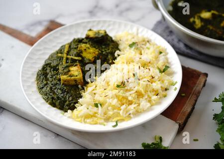 Paneer Palak fatto in casa o ricotta indiana spinaci curry servito con riso Foto Stock