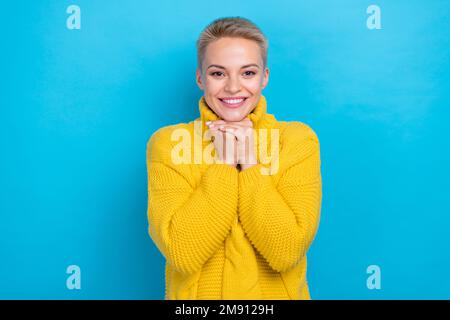 Foto di gioiosa allegra carina donna indossare comfort alla moda maglione gioire nuovo anno regalo presente isolato su sfondo di colore blu Foto Stock