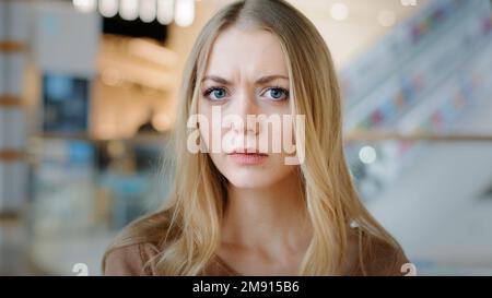 Primo piano femmina faccia interna ritratto biondo 20s ragazza donna millenario donna donna donna confuso femmina guardando la macchina fotografica con interesse alla ricerca di qualcuno che ascolta Foto Stock