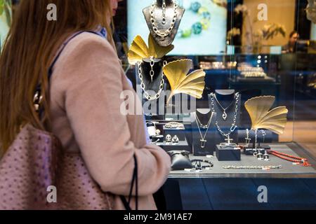 Shopping immagine simbolo: Giovane donna in piedi di fronte a una gioielleria (modello rilasciato) Foto Stock