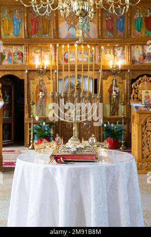 Uno scatto verticale di un portacandele dorato con due corone all'interno di una chiesa ortodossa. Matrimonio ortodosso. Foto Stock