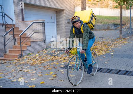 Consegna uomo in bicicletta consegna cibo e bevande in città all'aperto su una bicicletta elegante e zaino. Foto Stock