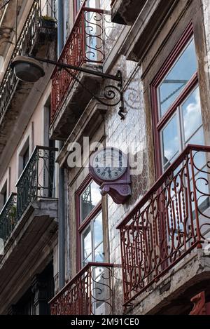 Vintage orologio a parete fatiscente su classico edificio di appartamenti architettura portoghese rivestito con piastrelle tradizionali a Lisbona, Portogallo Foto Stock