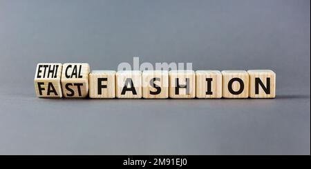 Simbolo di moda etico o veloce. Concetto di parole moda veloce ed etica su cubi di legno. Bellissimo sfondo grigio tavolo. Business veloce o. Foto Stock