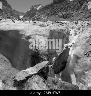 Il torrente glaciale sul ghiacciaio Mer de Glace con il Garand Jorasses sullo sfondo. Foto Stock