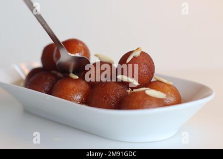 Gulab jamun. Un dolce a base di latte solido popolare nel subcontinente indiano. Palline morbide e fritte, di dimensioni frutti di bosco, realizzate con solidi di latte, per tutti gli usi f Foto Stock