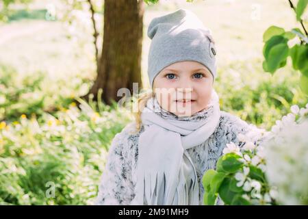 Una bambina in natura ammira la fioritura bianca degli alberi primaverili Foto Stock