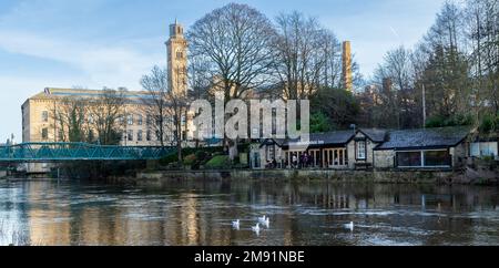 Il fiume Aire a Saltaire, Yorkshire, Inghilterra in inverno. Salts Mill è sullo sfondo e la casa pubblica Boathouse Inn è sulla riva del fiume. Foto Stock